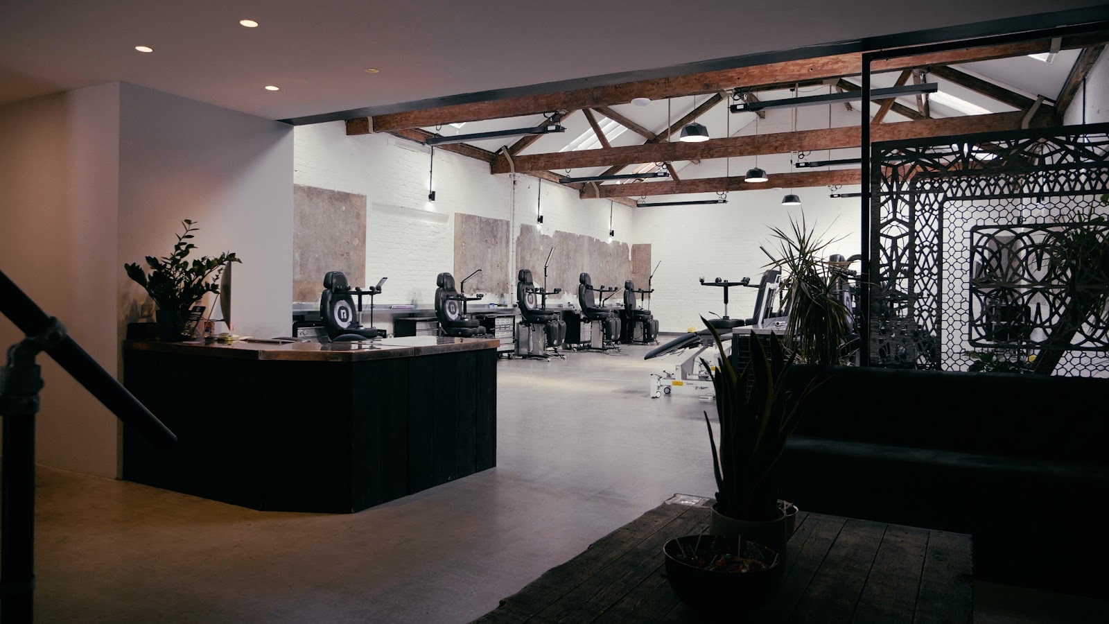 Inside No Regrets Studios: tattoo stations under exposed roof beams and skylights