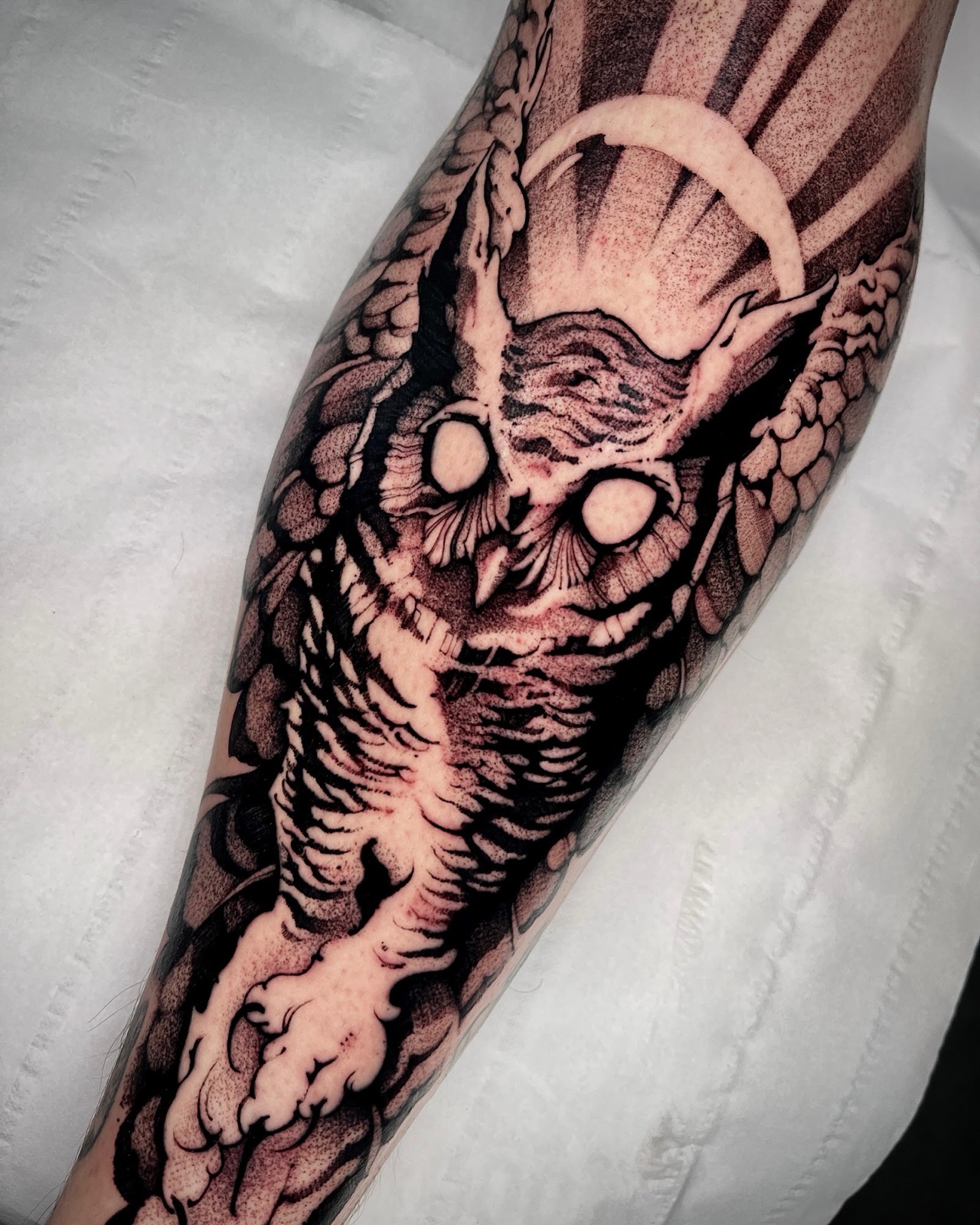 Blackwork owl forearm tattoo with heavy stipple shading