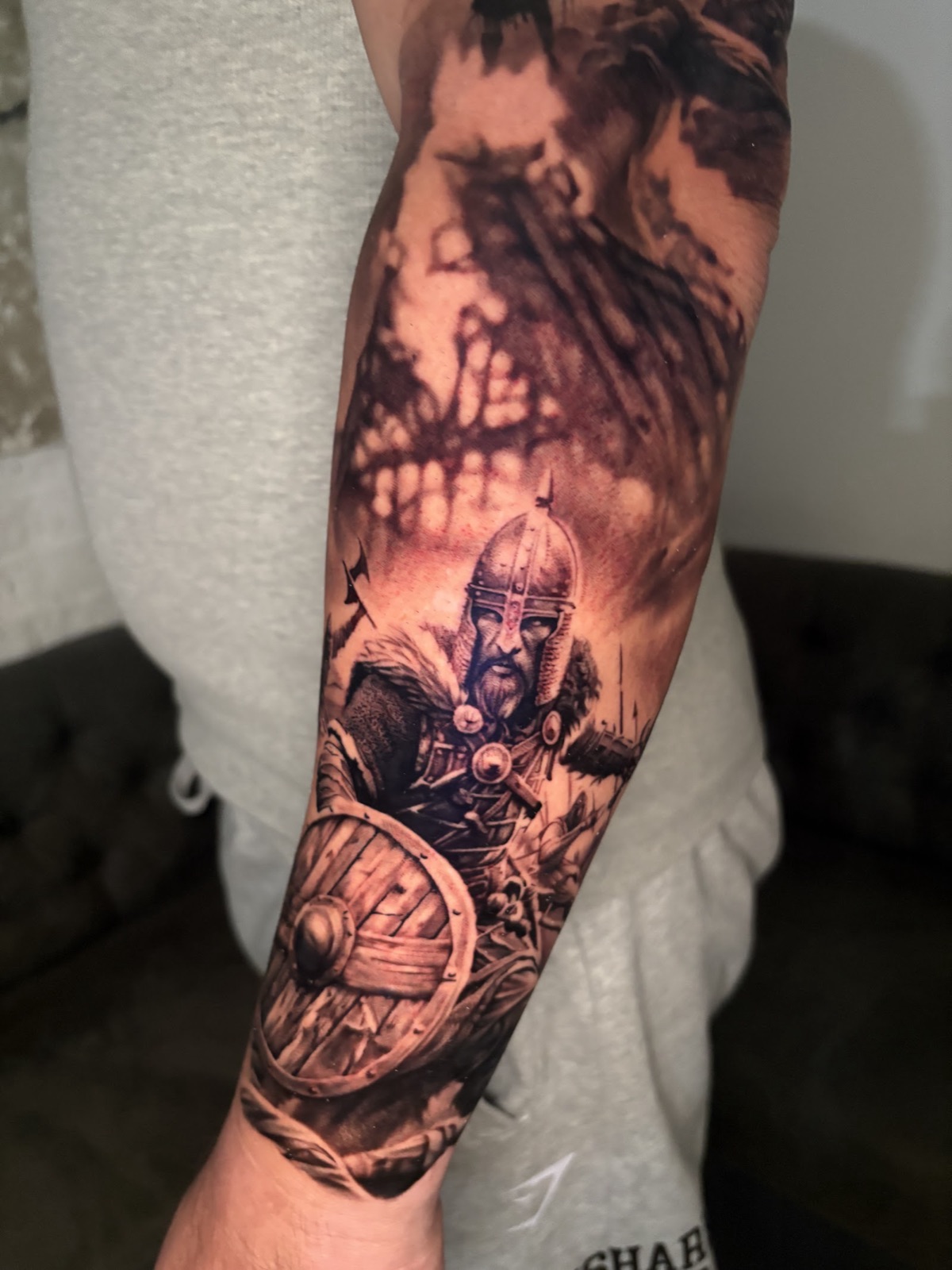 Black and grey realism forearm sleeve of a Norse warrior with a shield